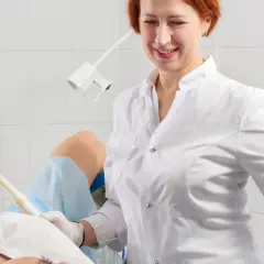 Lekarka bada pacjentkę, która leży na fotelu ginekologicznym. Specjalistka używa sondy USG, aby zdiagnozować problemy, takie jak grzybica pochwy.
