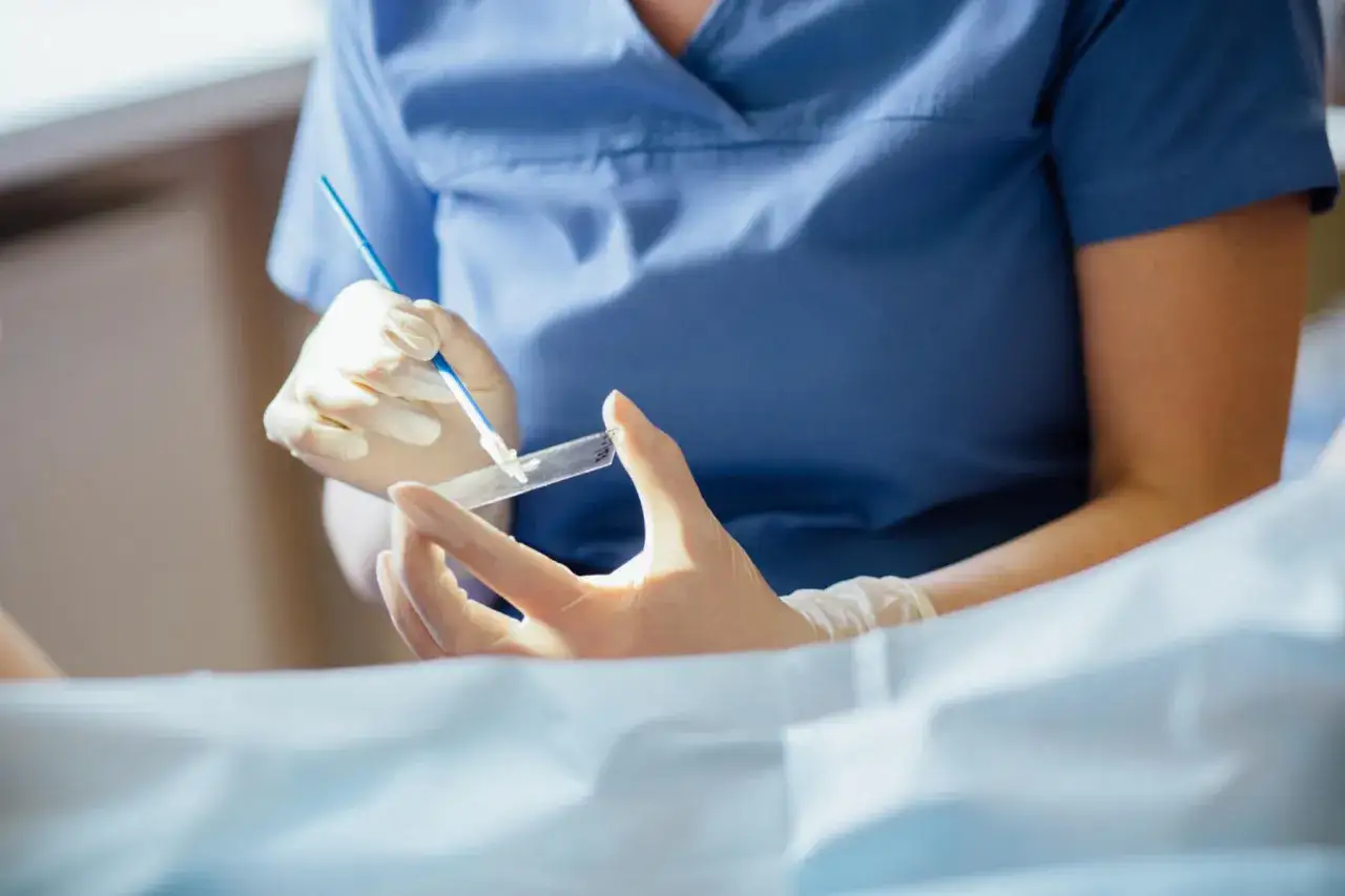 Lekarz w rękawiczkach pobiera wymaz do badania cytologicznego, kluczowego w diagnostyce raka szyjki macicy.